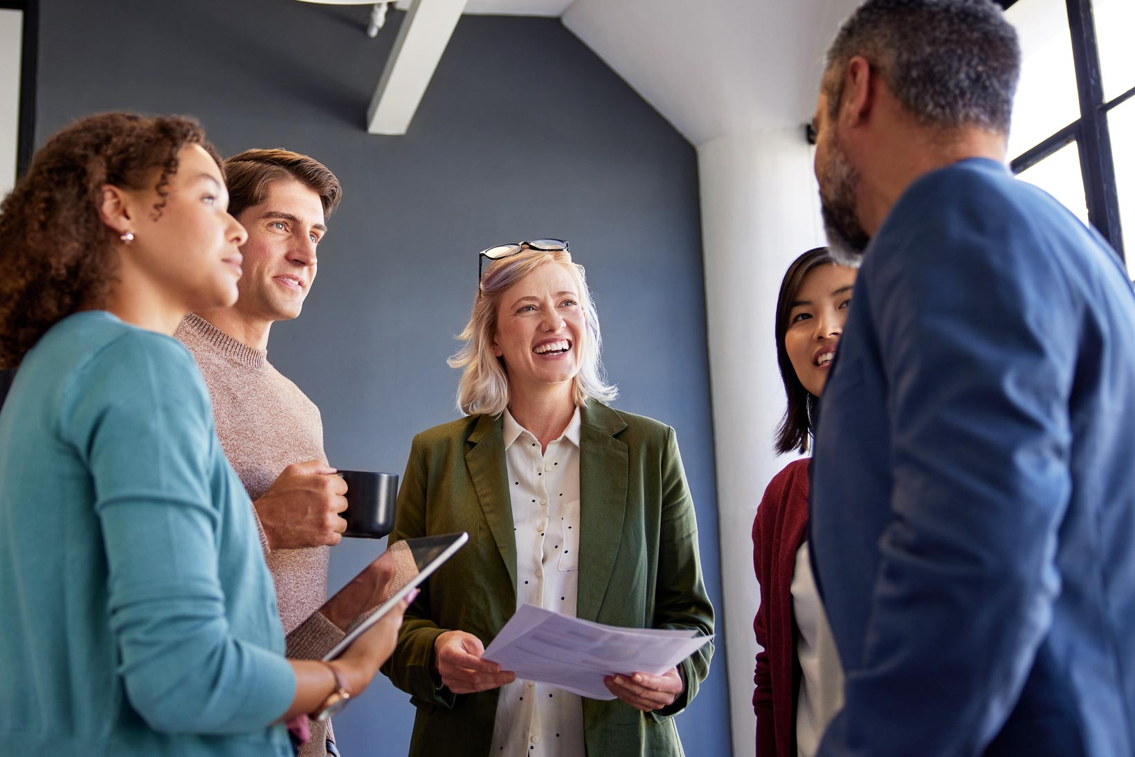 Diverse group of coworkers smiling during a business meeting.