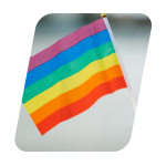 A rainbow pride flag waving gently against a blurred background.